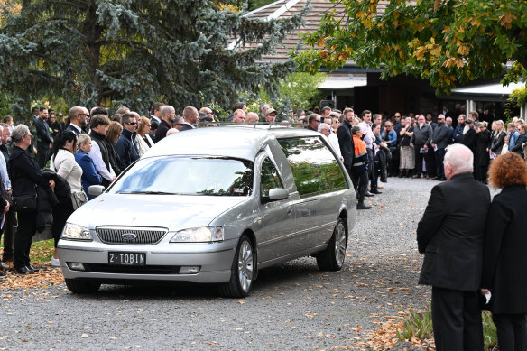 Friends and family watch as the hearse leaves Hannah McGuire’s funeral on Monday.