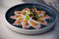 “New style” kingfish sashimi with salmon roe, pickled jalapeno and truffled dashi.