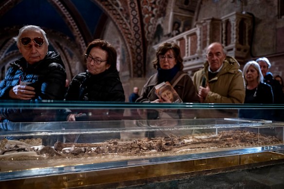 Faithful honor the remains of Italy’s patron saint, St. Francis of Assisi, during the public display to mark 800 years since his death, in the lower church of the Basilica of St Francis of Assisi on February 24, 2026 in Assisi, Italy. The venerated Christian figure, born in the 12th Century, is known for renouncing his wealth and devoting his life to the poor, and found the Franciscan order.