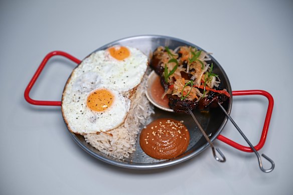 Tapsilog is a popular breakfast of beef skewers, fried eggs, garlic fried rice, banana ketchup and pickles.