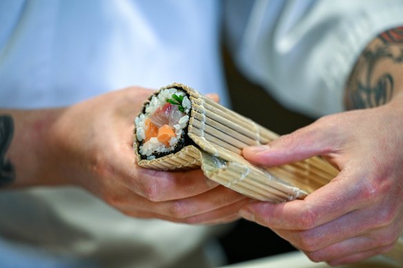 Place the sushi roll on the bamboo mat and gently squeeze it.
