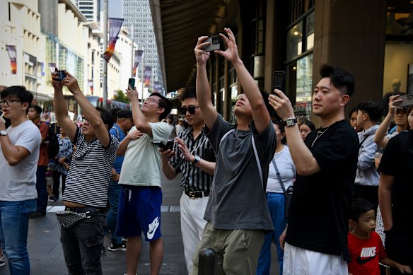 Easter Sunday shoppers record the protestors on their way to Hyde Park. 