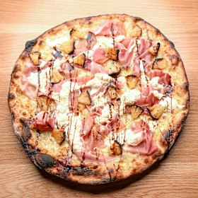 A smoky pineapple pizza with prosciutto and stracciatella cheese.