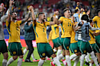 Socceroos players celebrate their progression to the Round of 32.