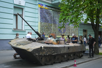 People look at a Russian military vehicle destroyed by the Ukrainian troops in a battle against the Russian invaders and taken to the capital as a reminder of war in Kyiv.