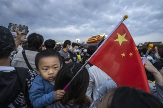 A boy holds a Chinese flag as people gather next to Tiananmen Square on October 1. 