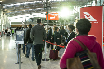 Qantas domestic passengers queue for security at Sydney Airport in June.