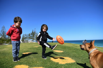 Wembley Downs locals Flynn and Beau Campbell play with pet dog Percy in Scarborough.