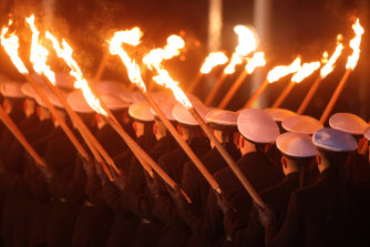 Members of the German armed forces carry torches as they march during a military tattoo ceremony, hosted by the Bundeswehr, for outgoing German Chancellor Angela Merkel.