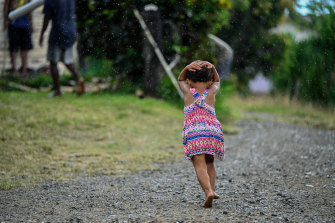 Fiji'deki Navunisabisabi köyünde bir kız yağmurdan kaçıyor. 