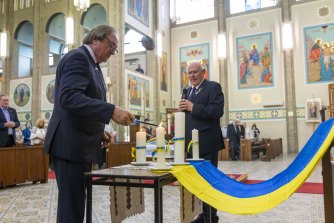 Kevin Sheedy lights a candle at the Ukrainian Catholic Cathedral.