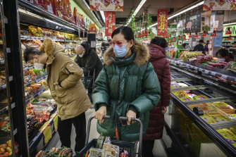 A Chinese woman wears a protective mask and sunglasses as she shops in Beijing on January 28.