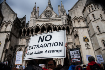 Supporters of Julian Assange hold up a sign as they gather outside the Royal Courts of Justice during an appeal hearing for his extradition in London on Thursday.