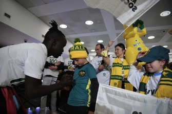 Socceroos forward Awer Mabil greats the fans at Sydney Airport. 