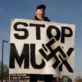 A protester stands outside a Tesla showroom in West London.
