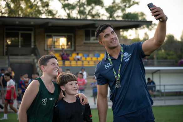 Joseph-Aukuso Suaalii poses with two young players at Nepean Rugby Park in Penrith.
