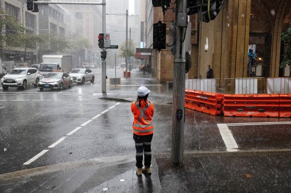 A traffic controller endures the rain in the CBD on Wednesday.