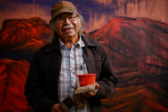 Artist George Cooley beside his work The Western Side of Mount Woodroffe painted for NGA’s Ngura Pulka exhibition.
