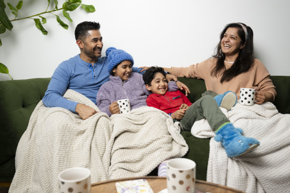 Anshul Wadhwa and Aradhita Nadkarni with their children, Aanya, 10, and Asher, 7, keep warm in their Randwick flat with hot chocolates, blankets and warm clothes.