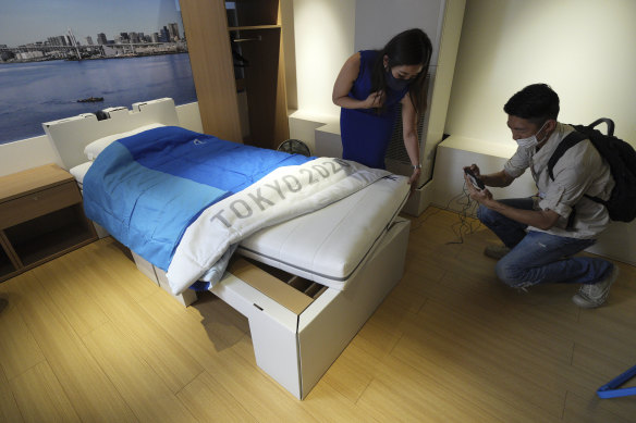 Journalists look at cardboard beds at the athletes village of the Tokyo Olympics and Paralympics prior to the start of the Games.
