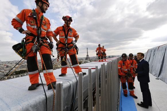 French President Emmanuel Macron speaks with the rope technicians.