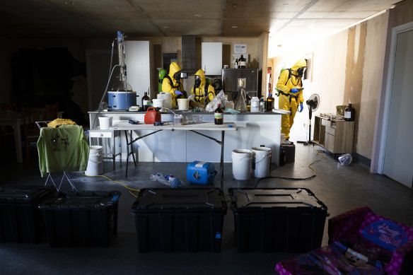 Regional police and firefighters during a training course inside a simulated suburban home littered with children’s toys and caustic chemicals.