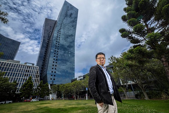 Wilbur Tong em frente ao edifício Marina Tower em Docklands, administrado pela Bluestone OCM. Tong está liderando a ação coletiva contra o gigante dos estratos.
