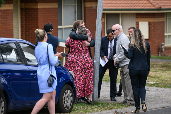 The happy winning bidders hug after buying the home.