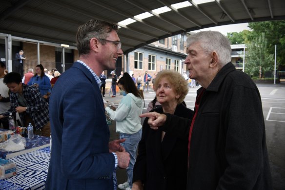 NSW Premier Dominic Perrottet speaking with voters at a polling booth in Bennelong on Saturday.