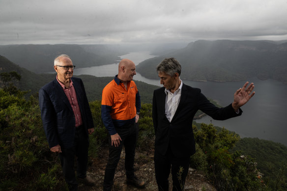 Ross and Anthony Garnaut, director and chief executive of Zen Energy, stand on either side of the WaterNSW chief Andrew George at the site of the proposed Western Sydney pumped hydro project.