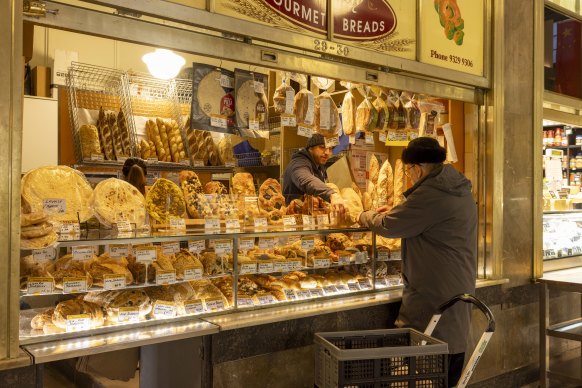 A shopper buys bread at the Queen Victoria market on Friday. 