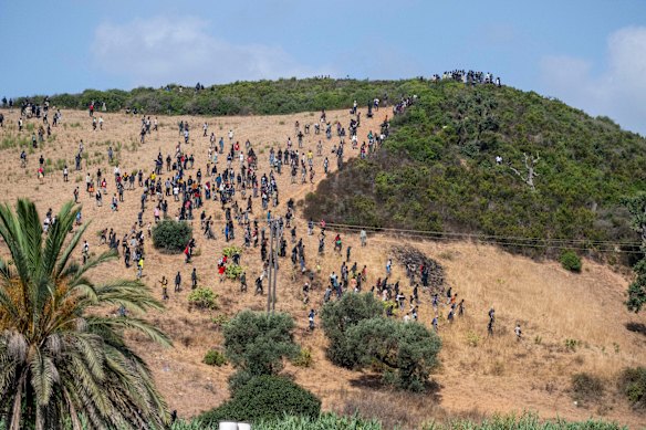 Migrants gather on a hill as they attempt crossing from the border town of Fnideq to the Spanish enclave of Ceuta.