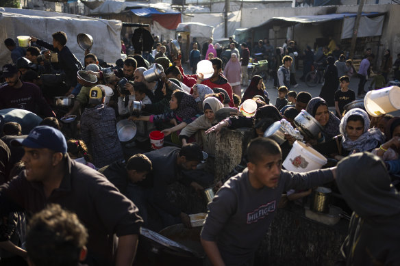 Palestinians line up to receive food in the southern city of Rafah.