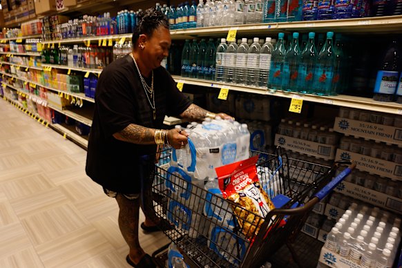 A shopper stocks up with bottled water in Hilo before the hurricane’s arrival.