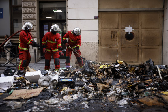 Firefighters in Paris put out a fire that was lit during protests against the French government’s retirement bill.