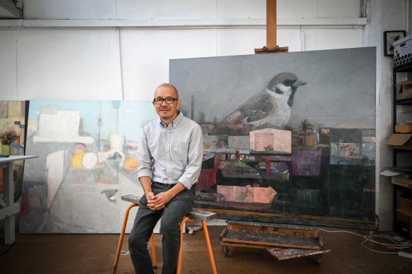 Shaun Tan surrounded by some of his paintings.