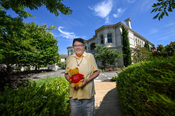 Jennifer Catlin and her childhood teddy bear at the former Presbyterian Babies Home in Camberwell on Monday.