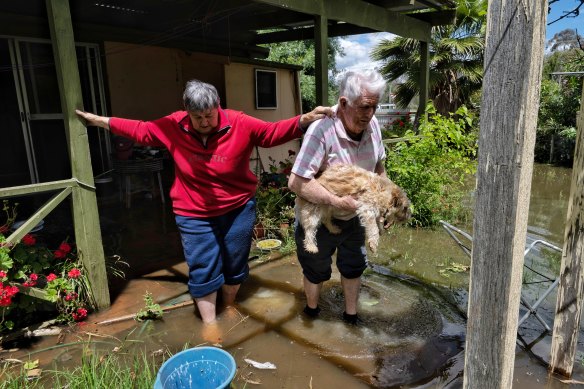 Peter and Robin Walker leave their home in Fenfree St in Forbes as the water levels continue to rise. 