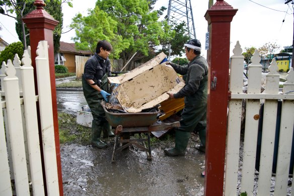 Hoang Nguyen and his wife Lam Luong cleaning up their home on Oakland Street in Maribyrnong. They say they have lost everything.