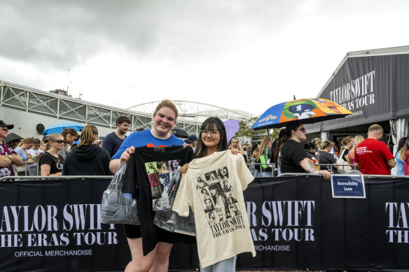 Taylor Swift fans Zoe Vacchini and Irene Lin with merchandise outside Accor Stadium on Thursday.