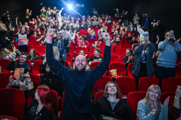 People celebrate as they watch a live screening showing the failed vote of confidence on the Prime Minister Morawiecki cabinet during a parliament session at the Kinoteka cinema in Warsaw.