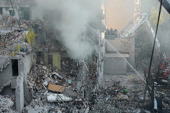 Il personale dei servizi di emergenza lavora per spegnere un incendio dopo un attacco russo a Kiev.