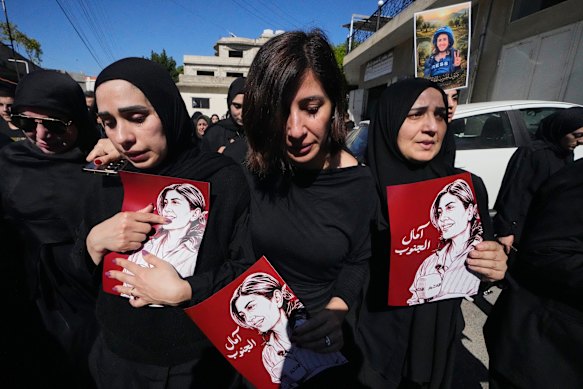 Mourners hold posters showing portraits of Lebanese journalist Amal Khalil.