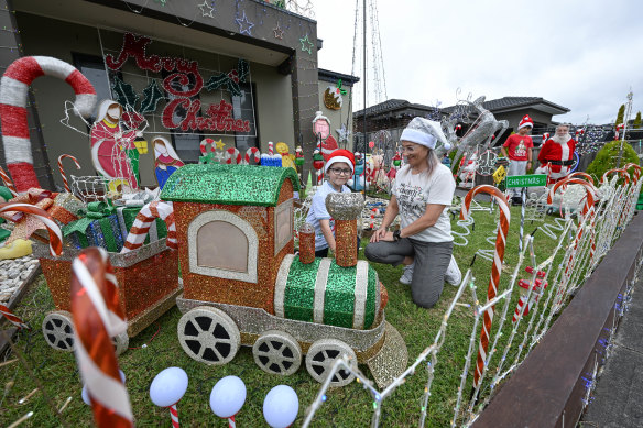Renee Gaitanis and son Tomas get the Santa train ready for Christmas on Thursday evening.