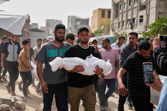 Saleh Zenati, carries the body of his infant nephew Khalid, who was killed by an Israeli army airstrike this month.