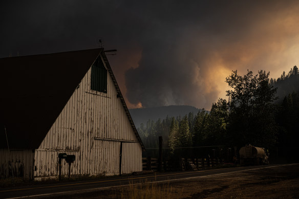 A huge, rotating fire column hangs over the mountain.