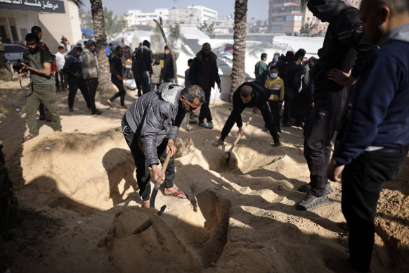 Palestinians dig graves at the Nasser hospital in Khan Younis to bury their relatives who were killed in the Israeli bombardment.