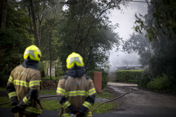 Firefighters survey the damage following a house fire in Donvale on Saturday morning.