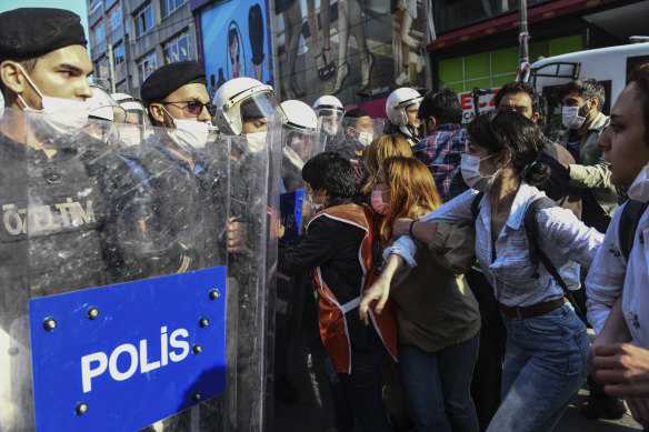 Turkish police officers in riot gear hold back protesters in Istanbul on Tuesday.