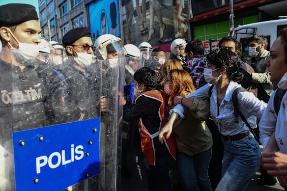 Turkish police officers in riot gear hold back protesters in Istanbul on Tuesday.